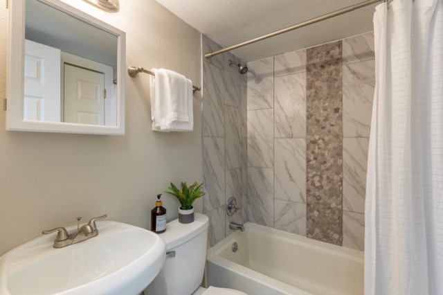 Renovated bathroom with tiled tub surround at The Jefferson